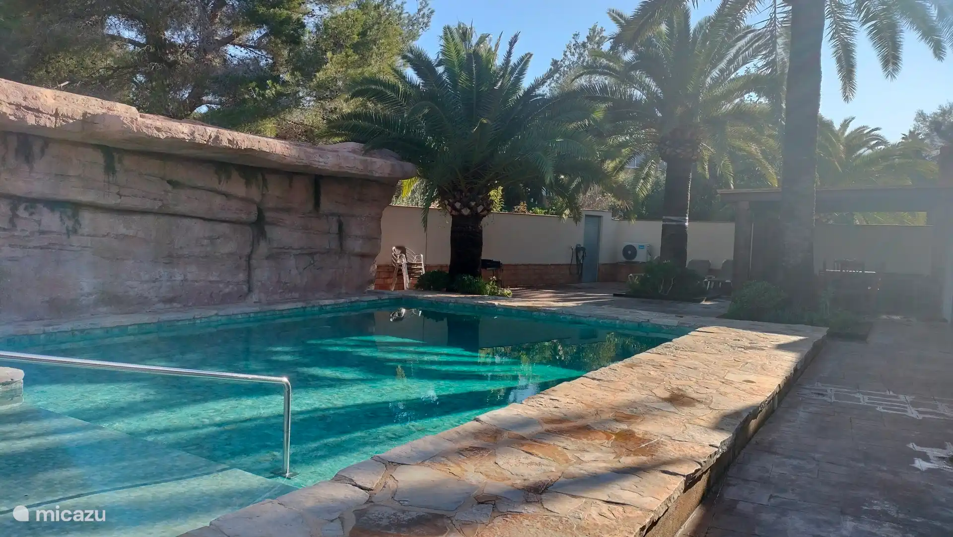 Swimmingpool, Palmen und Veranda