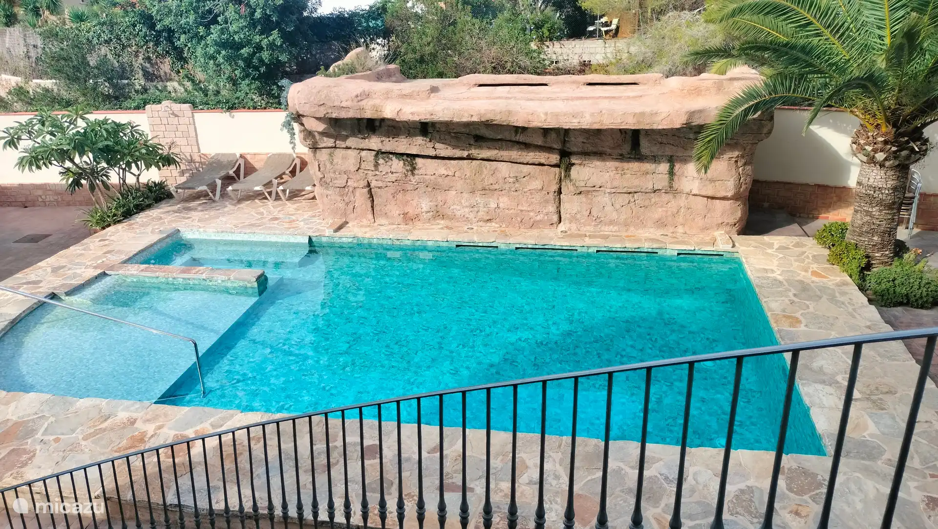 Schwimmbad am Strand, von 0 bis 1,90 tief, mit Wasserfall und Sitzbereich und Sonnenliege.