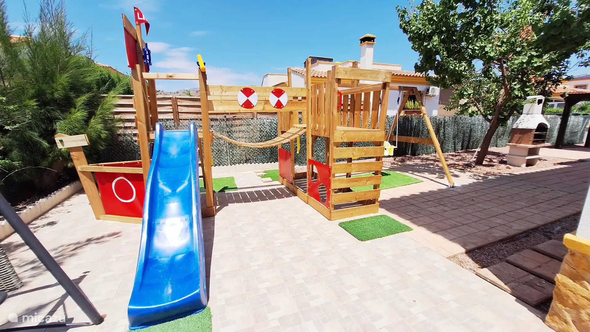 Parque infantil privado con tobogán, columpios y estructura de escalada 