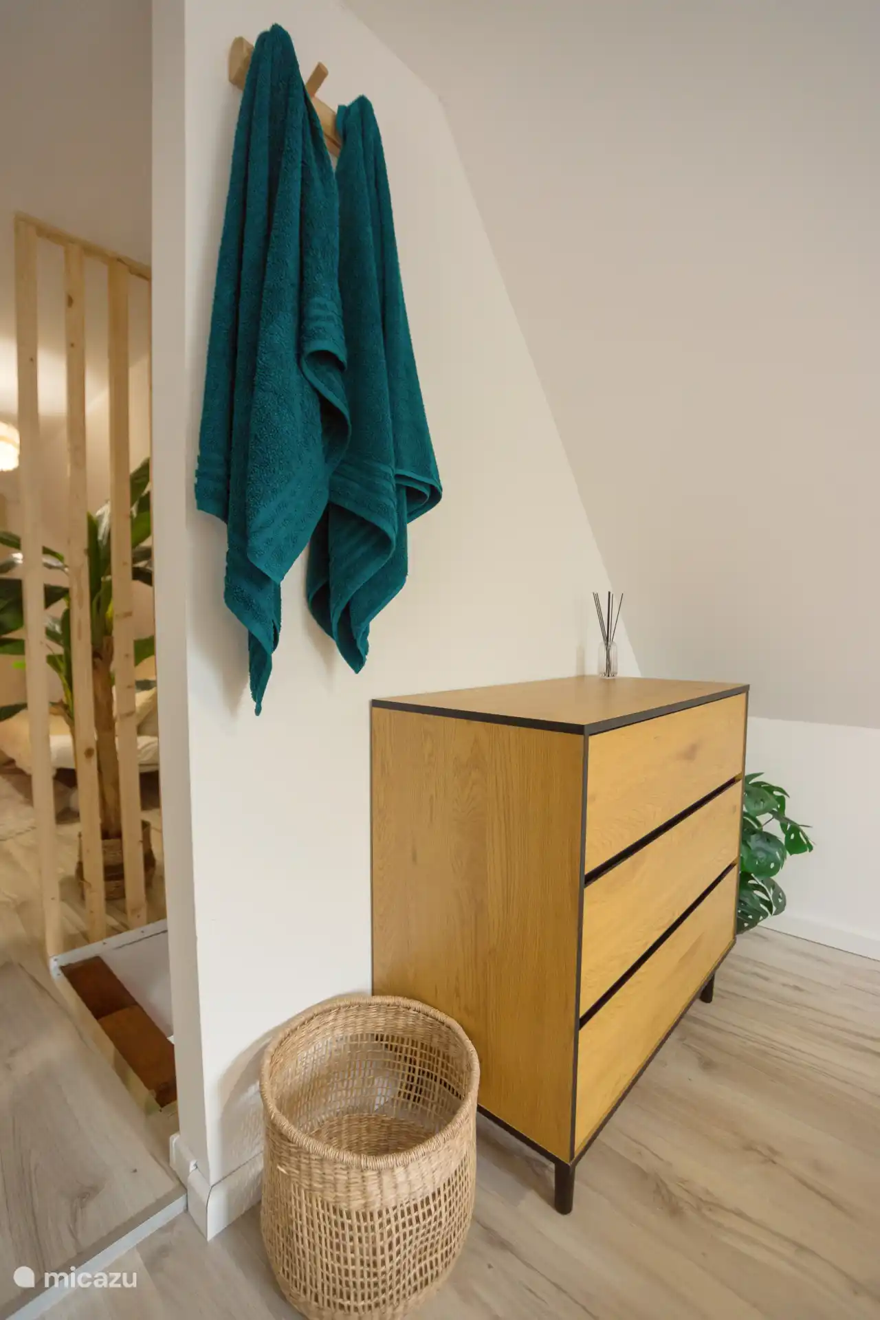 Une commode en bois élégante pour vos vêtements et un panier à linge tressé pour tout ce dont vous voulez vous débarrasser - pratique et beau dans ce coin tranquille de la chambre à coucher.