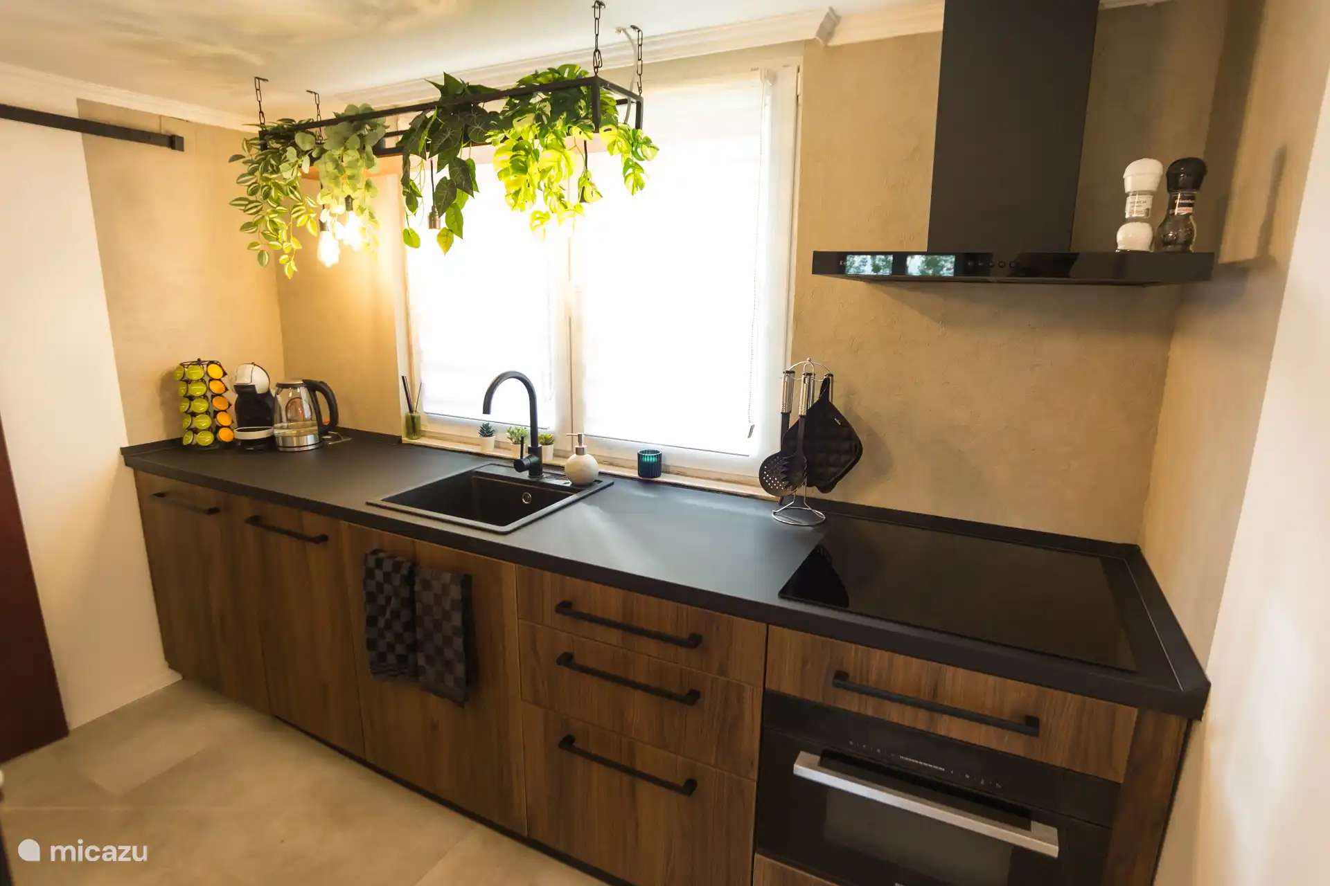 Avec une vue sur la verdure et entouré de détails atmosphériques, vous pouvez cuisiner ici en toute tranquillité. Tout est prêt : du café frais aux herbes, en passant par les casseroles et l’inspiration pour un dîner détendu.