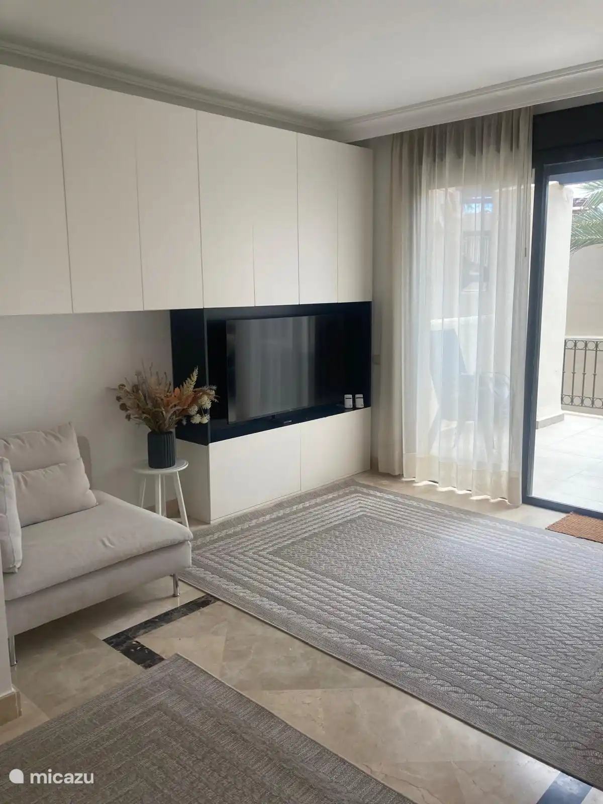 Im Wohnzimmer gibt es einen schön großen Fernseher und viel Stauraum in den Schränken.