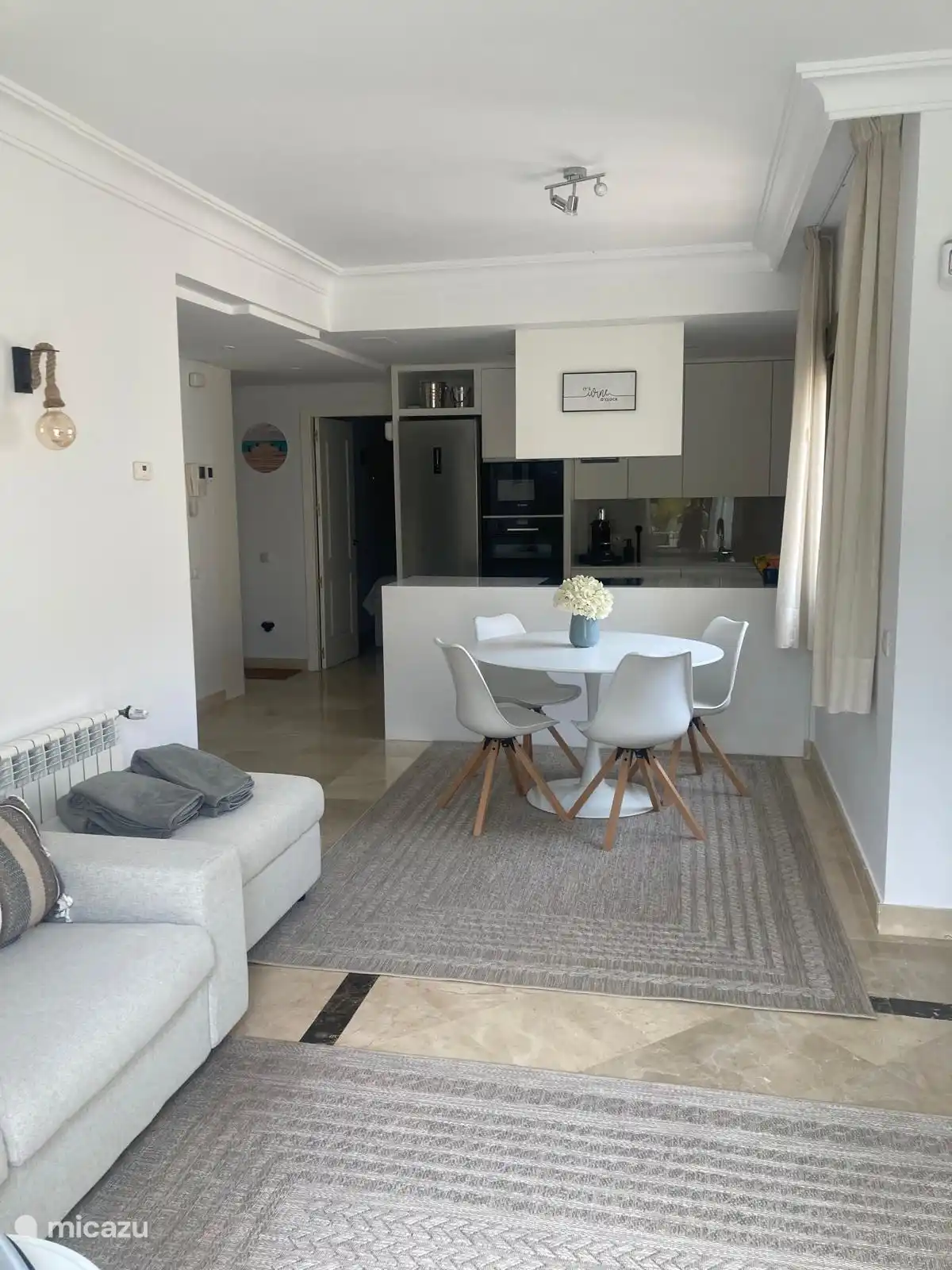 Es gibt einen runden Esstisch mit vier Stühlen. 