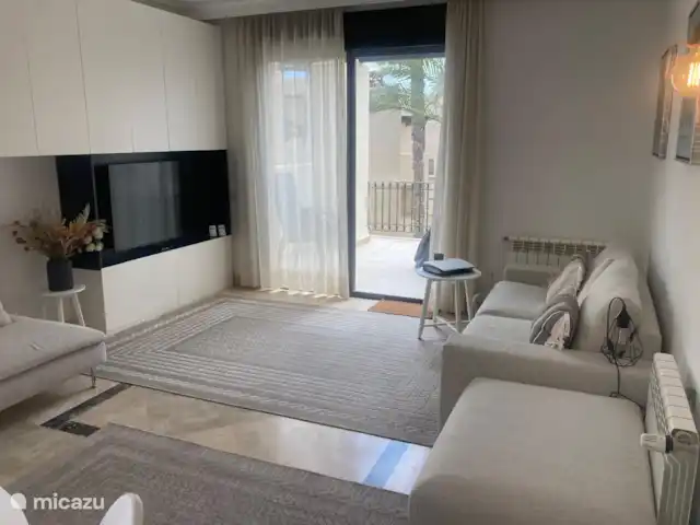 Location de Vacances Espagne, Costa Cálida, San Javier, penthouse - Penthouse Pentaguila  Le salon confortable dispose d’un canapé, d’un fauteuil confortable, d’un pouf et d’une télévision. Par les portes coulissantes, vous avez accès au balcon.