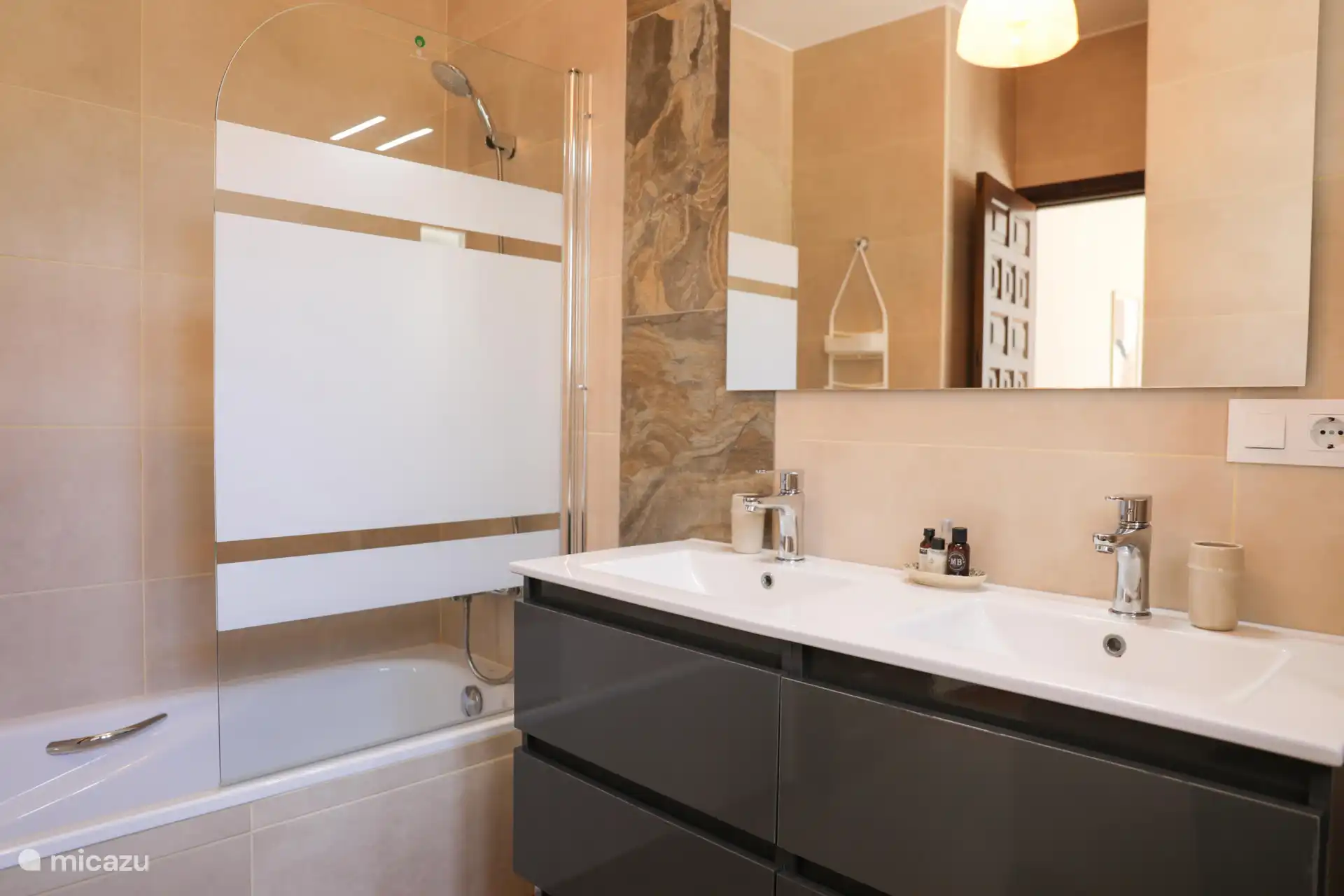 El cuarto de baño en el dormitorio 1 es espacioso y lujoso con un lavabo doble.