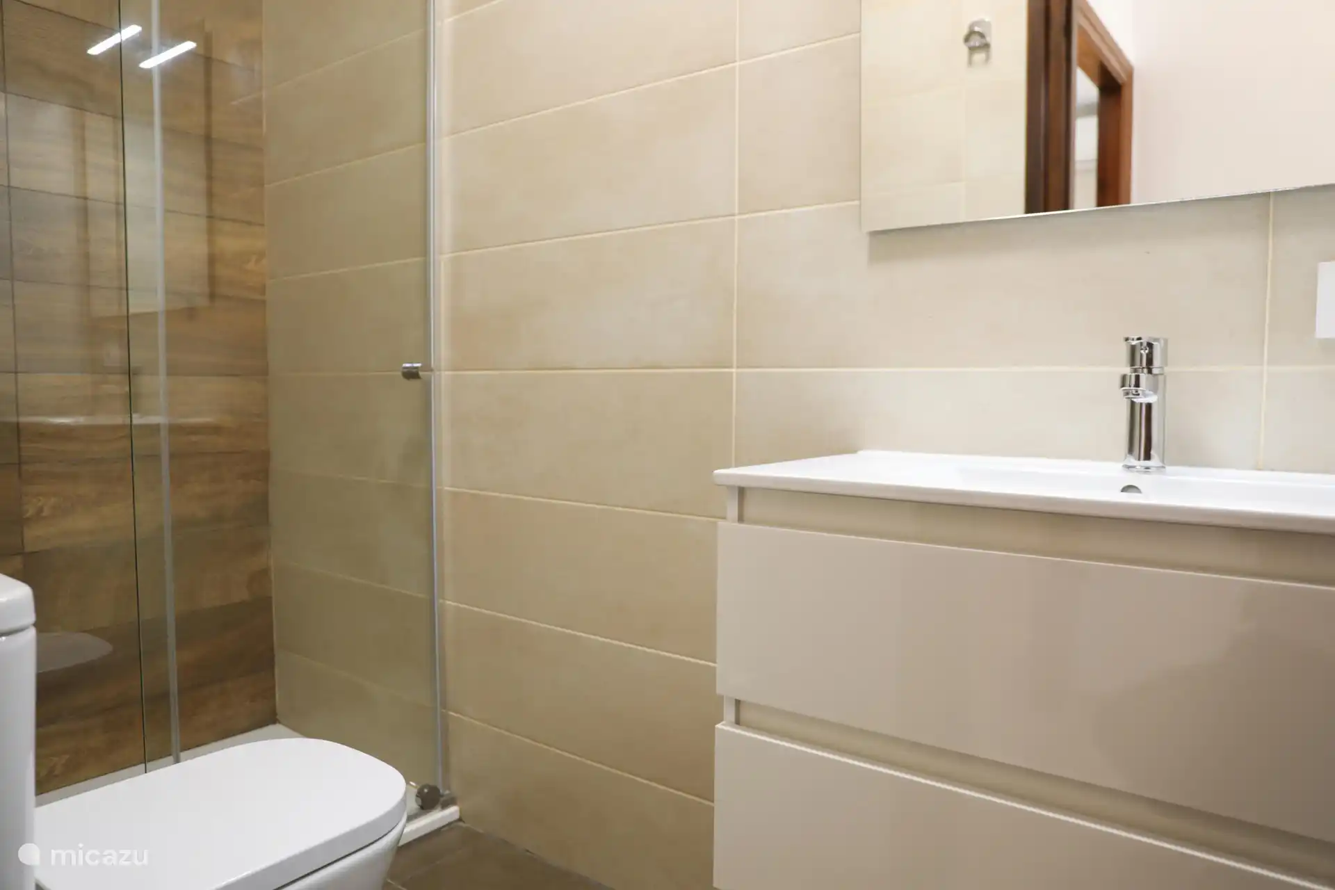 El segundo baño tiene una moderna ducha, inodoro y lavabo, ideal para invitados.