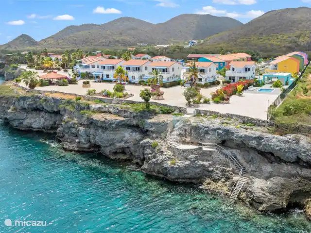 Bon Azul 5A en Curazao, Bandabou (oeste), Westpunt - casa vacacional Desde el mar se contemplan una serie de casas bellamente ubicadas, escondidas entre la vegetación. El mar azul claro y el entorno natural ofrecen una vista serena y virgen.