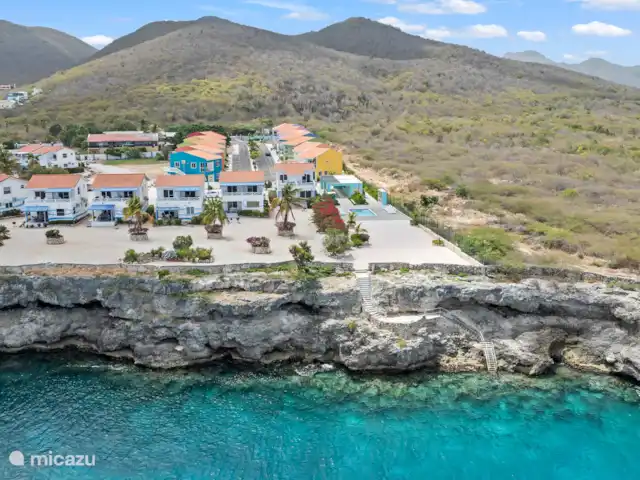 Bon Azul 5A en Curazao, Bandabou (oeste), Westpunt - casa vacacional Desde el mar se contemplan una serie de casas bellamente ubicadas, escondidas entre la vegetación. El mar azul claro y el entorno natural ofrecen una vista serena y virgen.