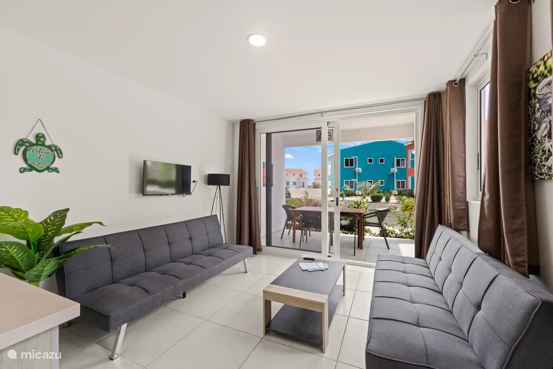 Sala de estar bien cuidada con televisión, amplio sofá y una atractiva decoración, perfecta para momentos de relax.