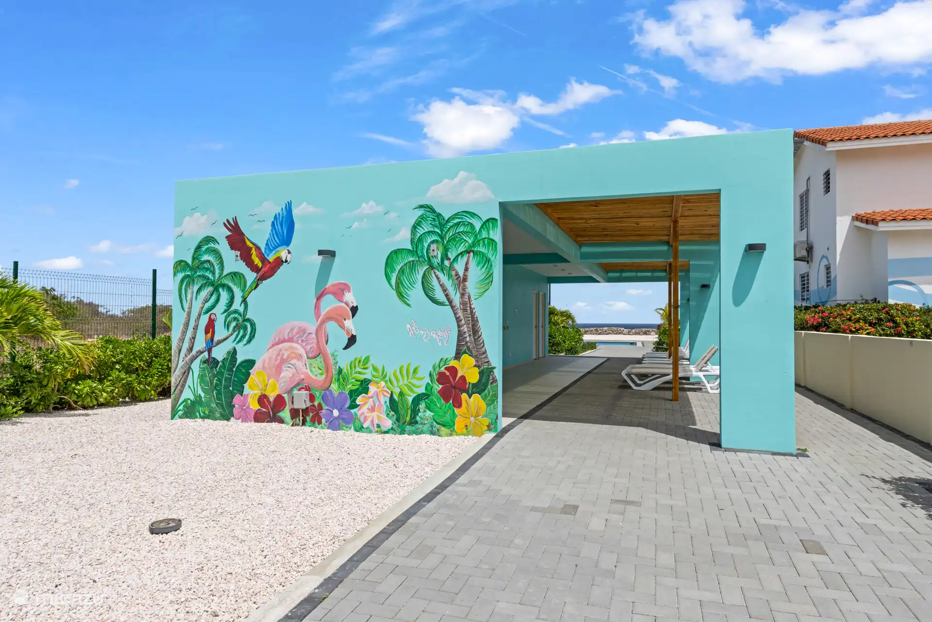 Ein auffälliges Wandbild am Poolhaus sorgt für einen verspielten, sommerlichen Look.