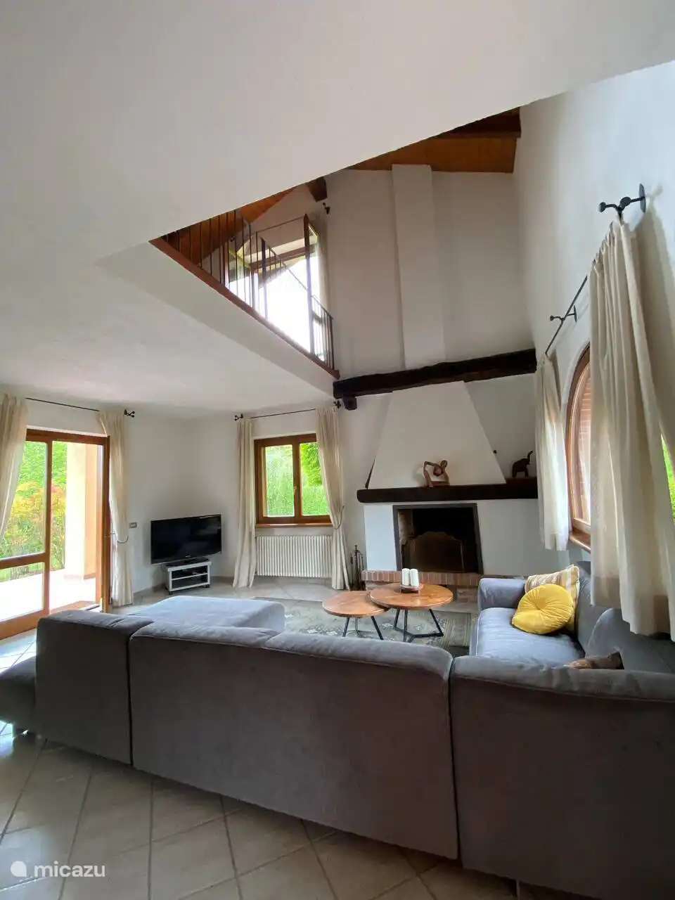 Salón comedor con chimenea, gran sofá y altillo