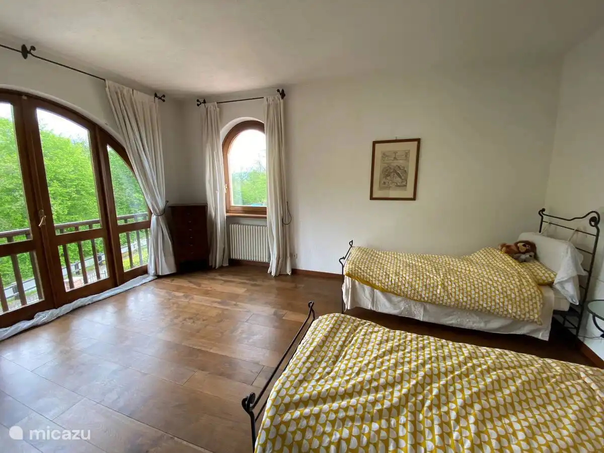 Segundo dormitorio con dos camas individuales y un baño contiguo y un balcón.