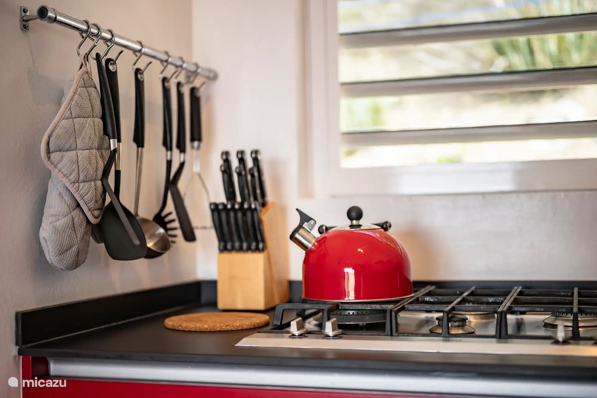 Von der modernen Küche aus blickt man auf den praktischen Hauswirtschaftsraum mit Waschmaschine – ideal für einen längeren, komfortablen Aufenthalt. Alles in Reichweite für ultimative Bequemlichkeit im Urlaub.