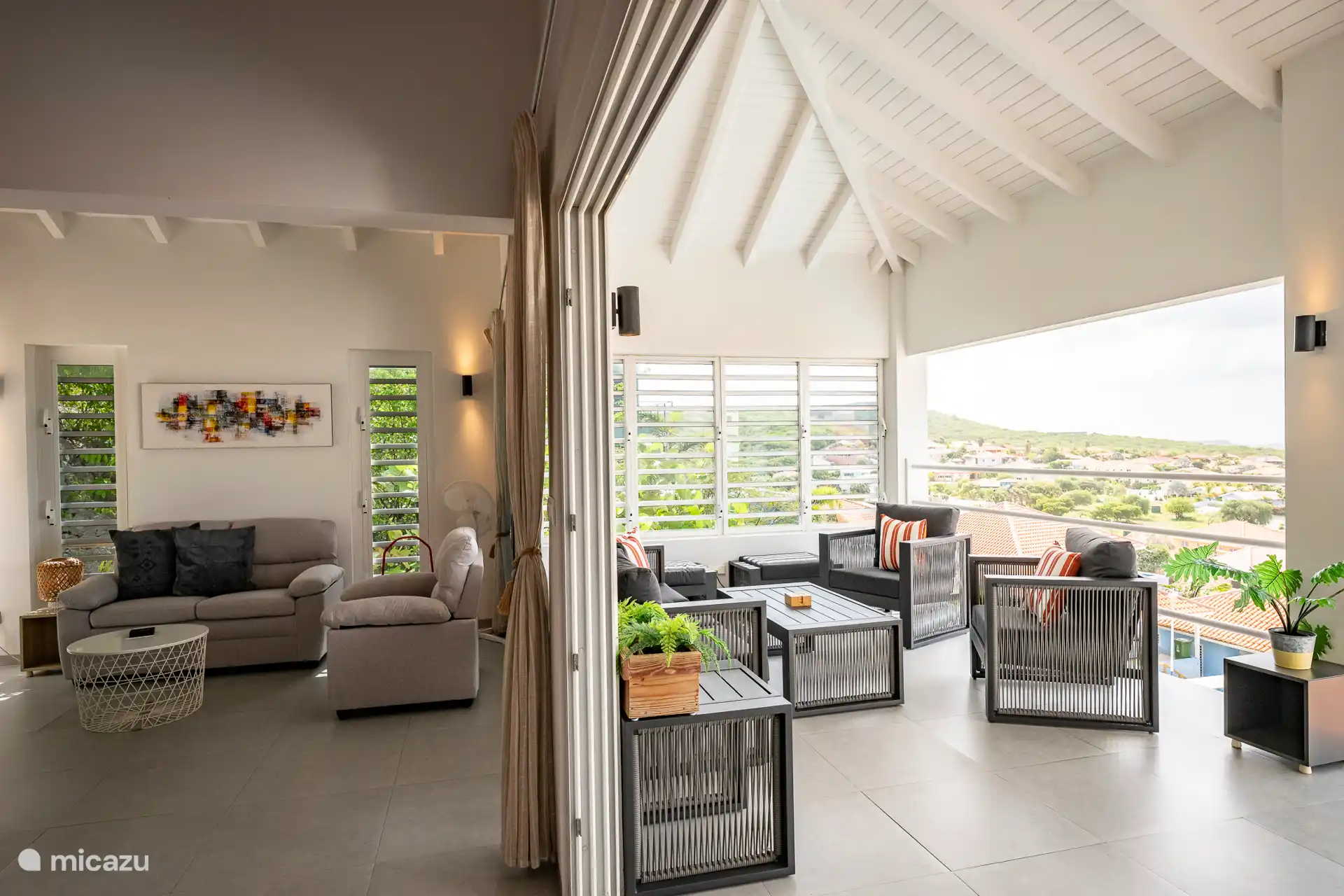 Geräumiger und heller Wohn- und Außenbereich mit hoher Decke, komfortablen Sitzbereichen und Panoramablick. Dank des offenen Layouts kann man sowohl innen als auch außen gleichzeitig genießen 