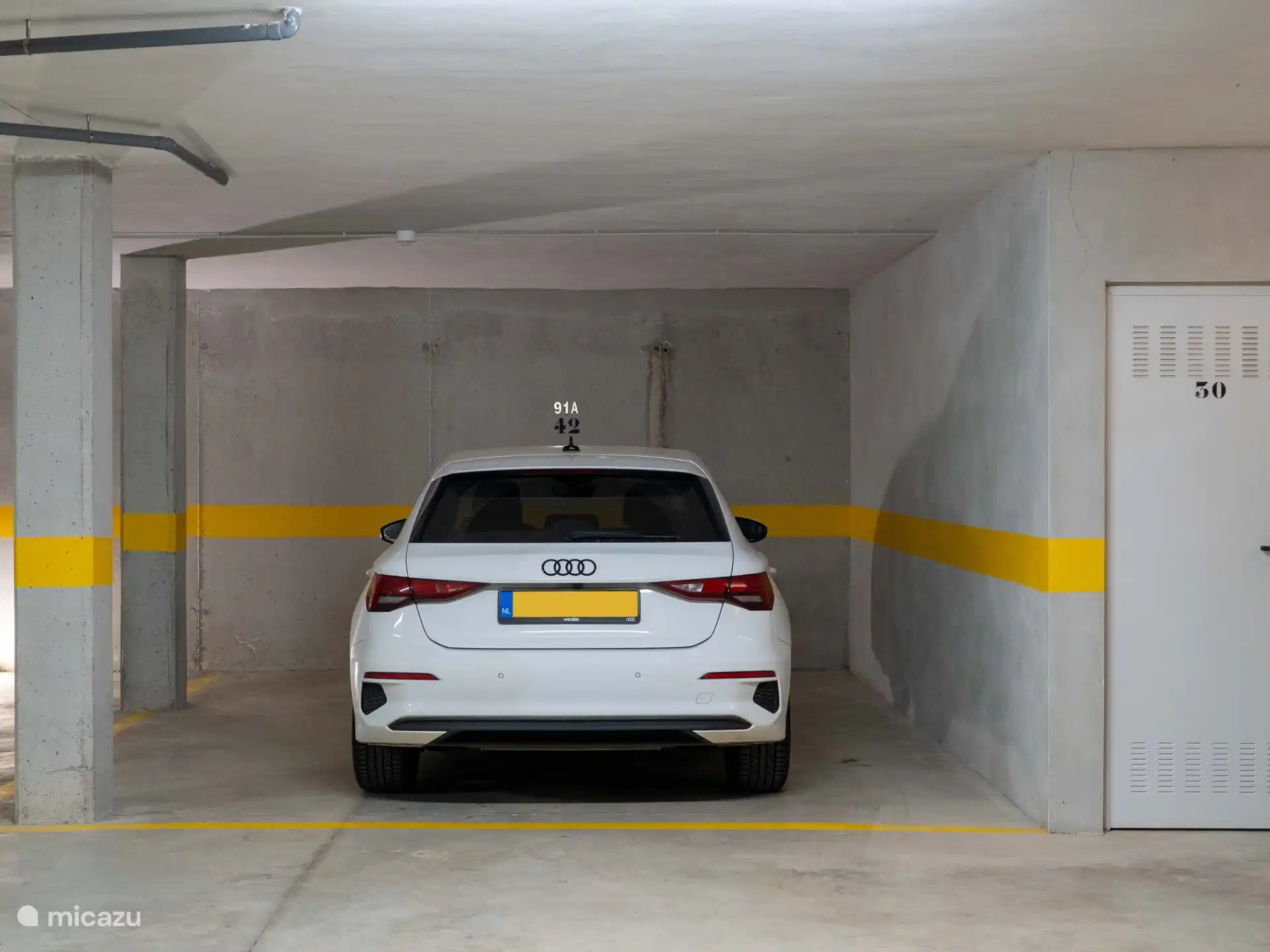 Grand parking souterrain privé avec ascenseur et escalier menant directement à la porte d’entrée de l’appartement.