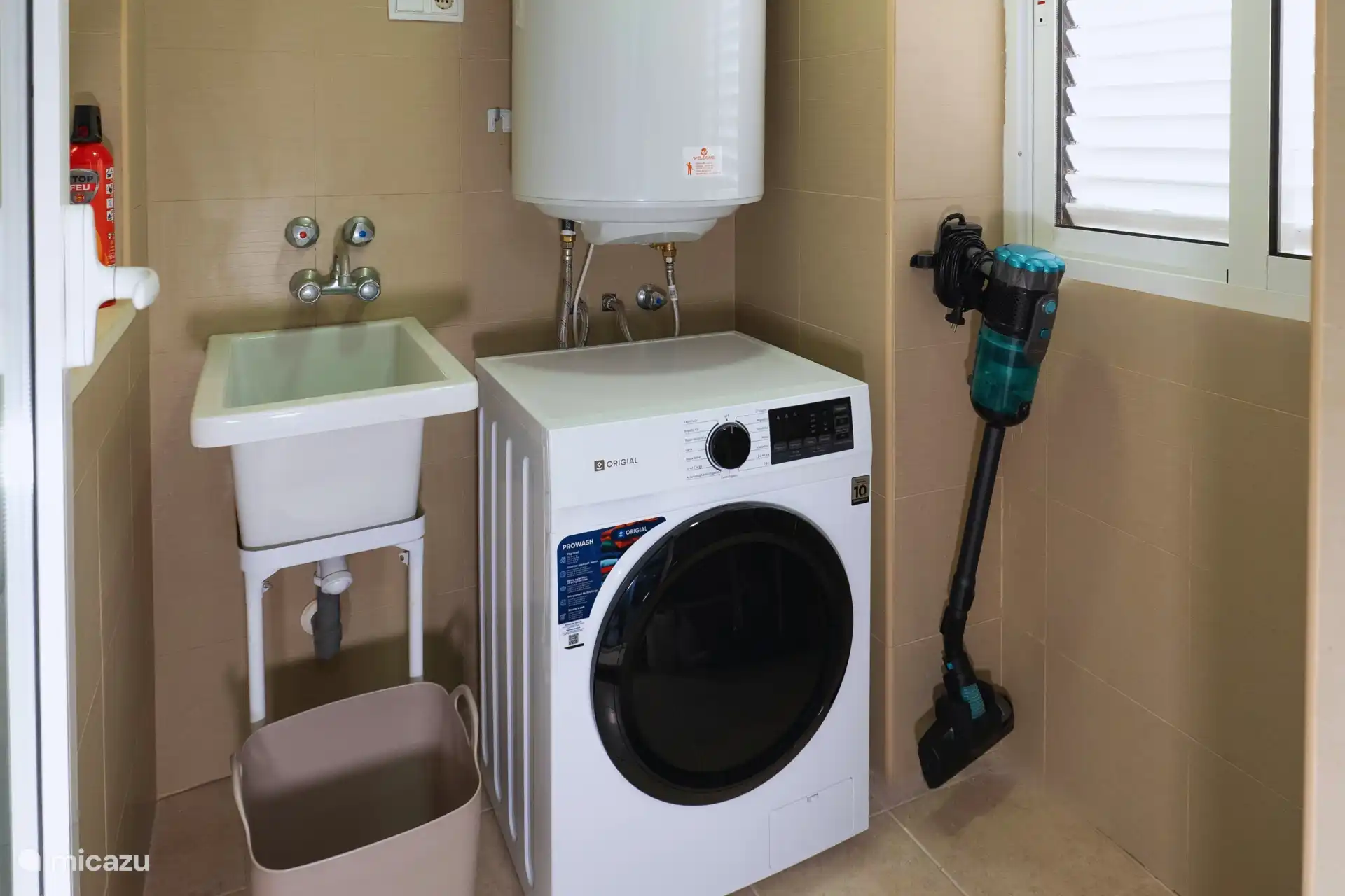 La propriété comprend une buanderie séparée avec toutes les commodités, y compris des produits de nettoyage et une machine à laver.