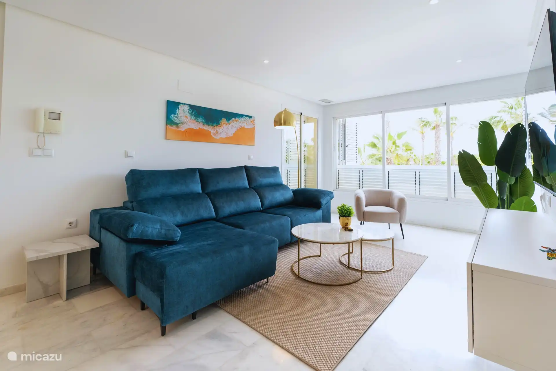 Espace de vie avec de belles vues sur les palmiers et de grandes fenêtres qui laissent entrer la lumière naturelle.