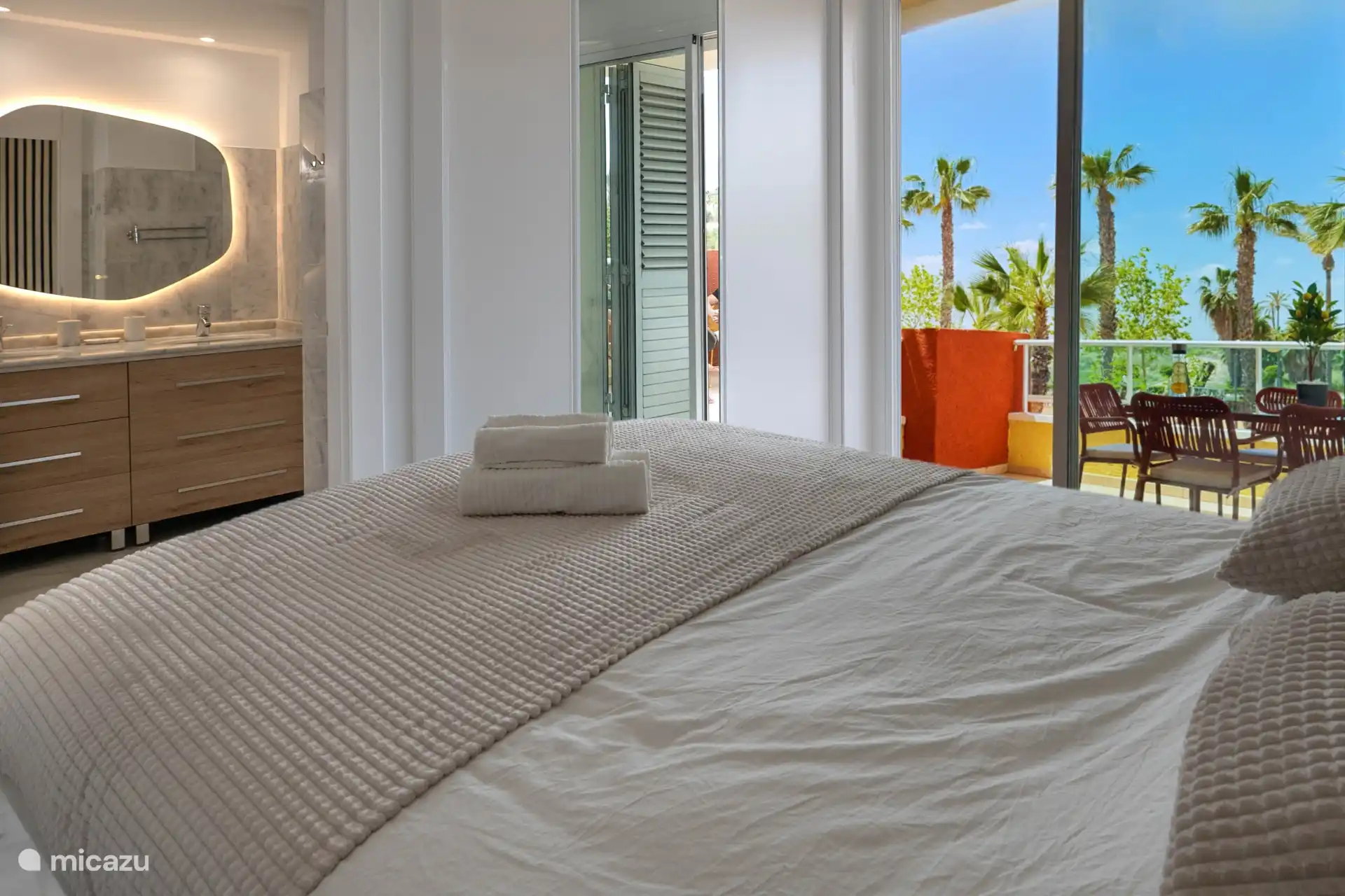 Chambre avec salle de bain privée, double vasque et grande armoire encastrée.