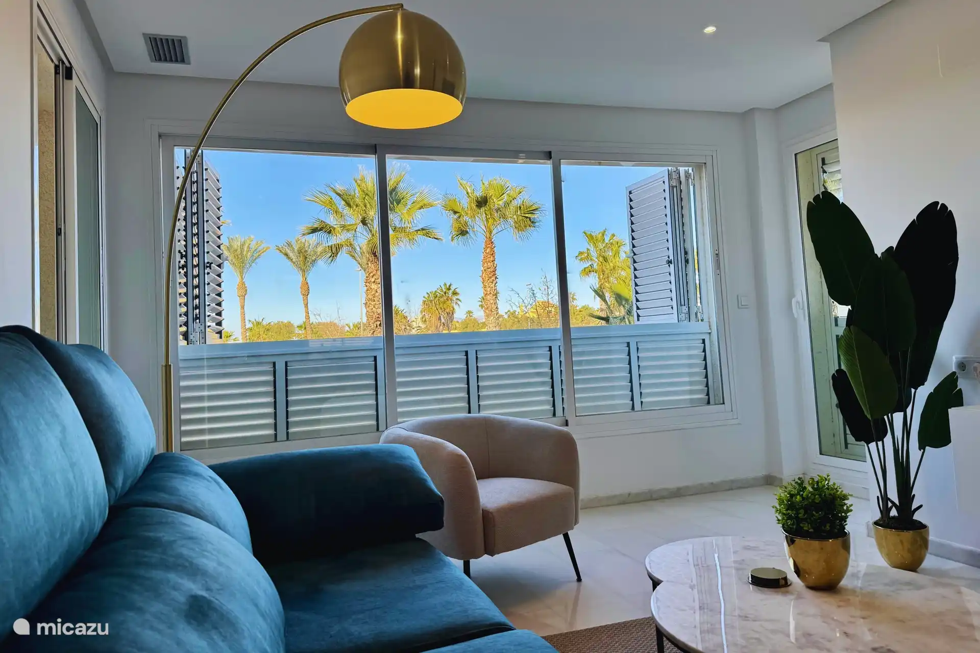 Espace de vie avec de belles vues sur les palmiers et de grandes fenêtres qui laissent entrer la lumière naturelle.