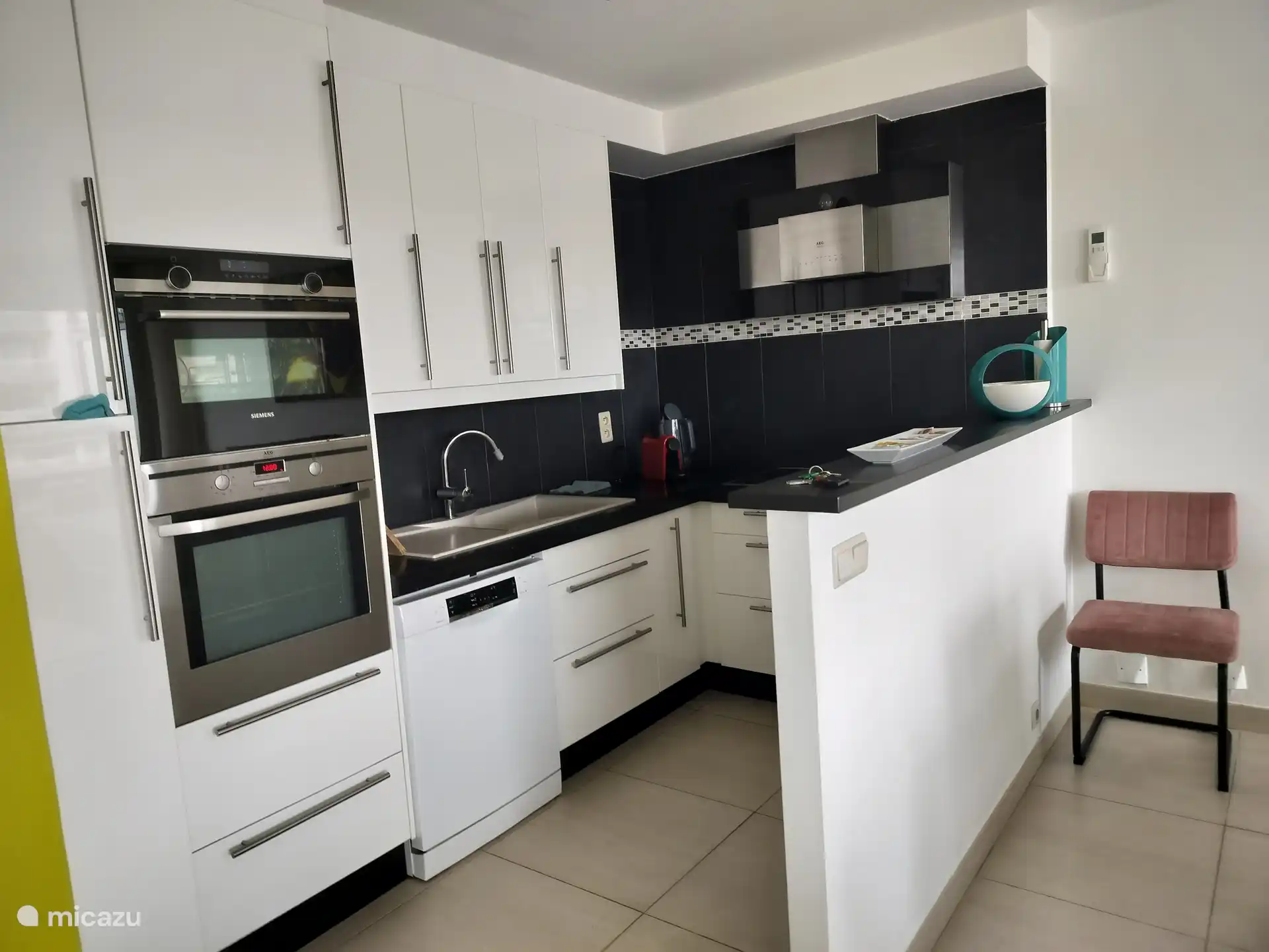 ingerichte keuken koffiezetapparaat, waterkoker, vaatwasser, micro en bakoven, vitrokeramische kookplaat. aansluitend berging met kuisprodukten en kuismateriaal diepvriezer en wasmachine. 