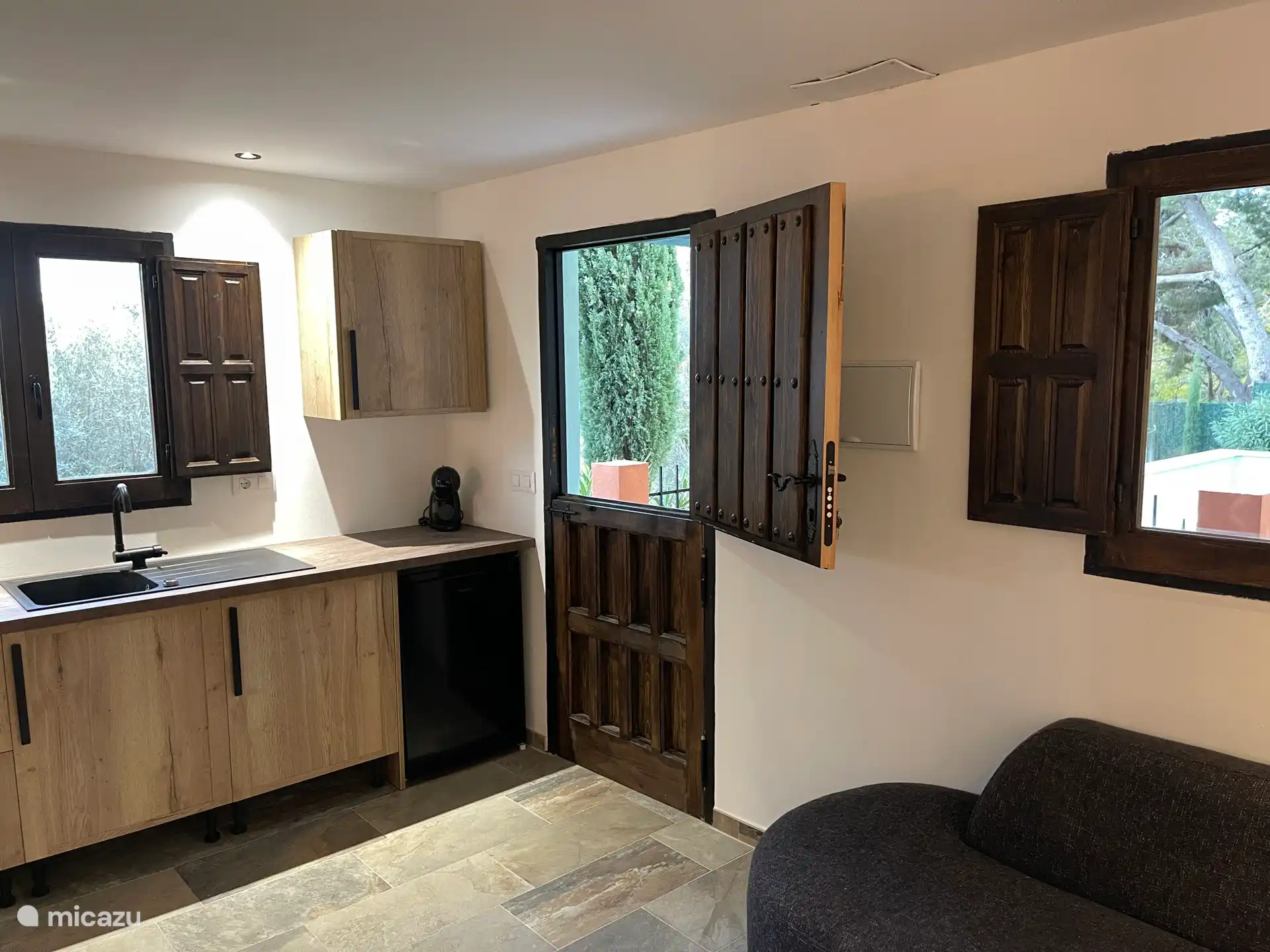 Cocina con la puerta del establo a la piscina comunitaria. desde la ventana se puede mirar a lo lejos al mar y a la ciudad de Valencia mientras se lavan los platos