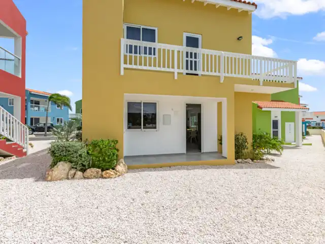 Punta Azul 12A Ocean resort  en Curazao, Bandabou (oeste), Lagun - apartamento Llamativo exterior amarillo que contrasta maravillosamente con la naturaleza circundante: una casa de vacaciones alegre y atractiva.