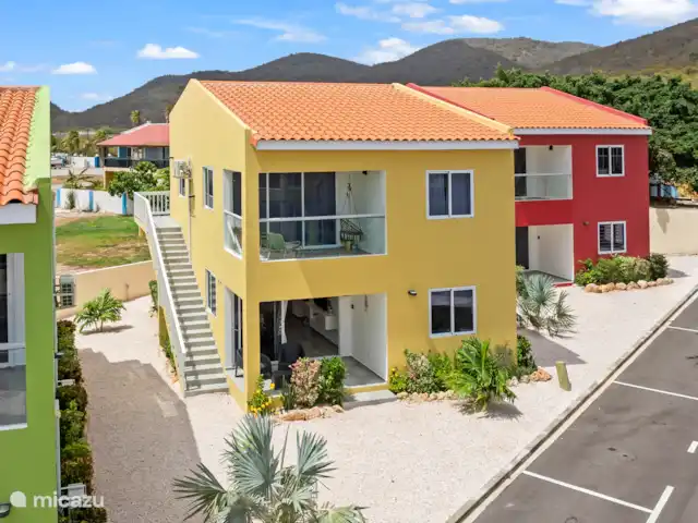 Punta Azul 12A Ocean resort  en Curazao, Bandabou (oeste), Lagun - apartamento Llamativo exterior amarillo que contrasta maravillosamente con la naturaleza circundante: una casa de vacaciones alegre y atractiva.