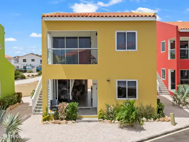 Punta Azul 12A Ocean resort  en Curazao, Bandabou (oeste), Lagun - apartamento Llamativo exterior amarillo que contrasta maravillosamente con la naturaleza circundante: una casa de vacaciones alegre y atractiva.