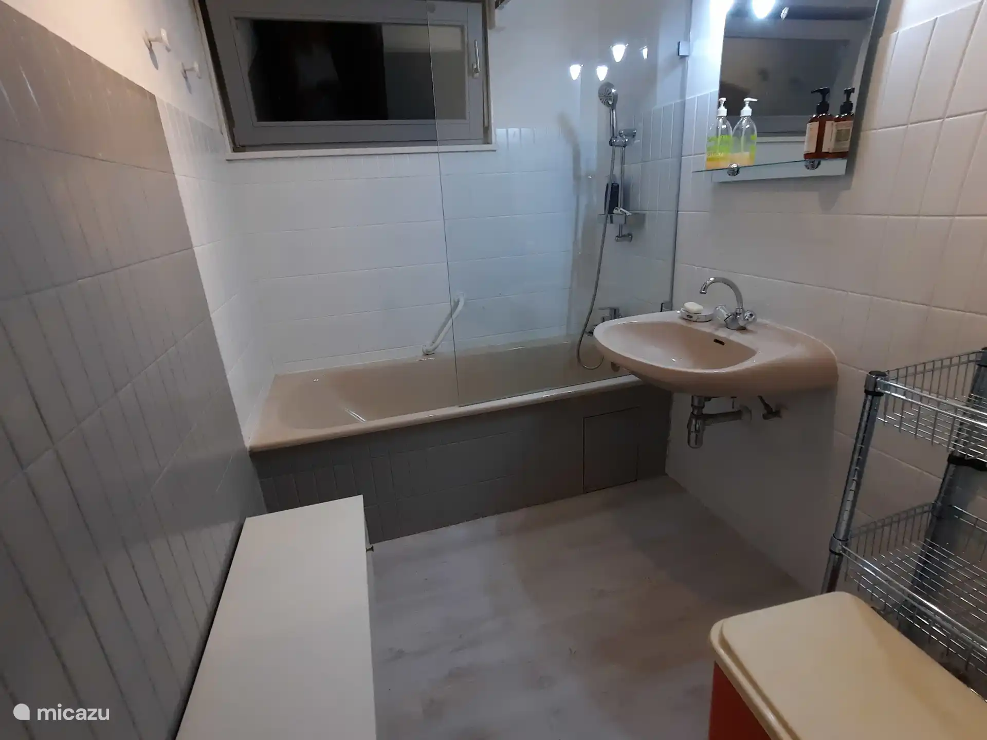 Badezimmer 1 mit WC, zwei Waschbecken und einer Badewanne mit breiter Duschwand, wo Sie bequem duschen können