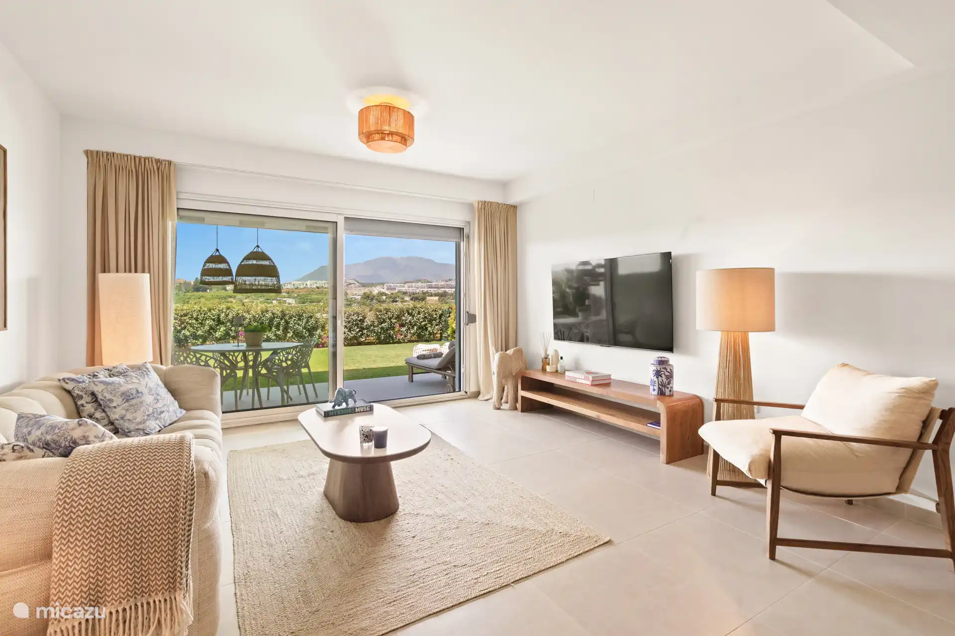 Salon lumineux et attrayant avec un coin salon confortable, une télévision connectée et un accès direct à la terrasse et au jardin privé.