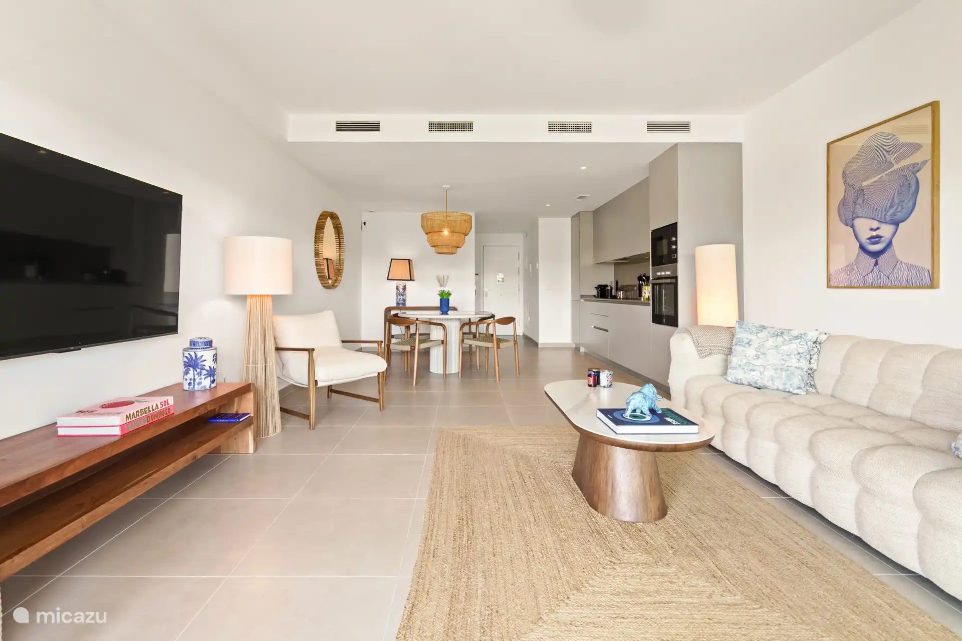 Espace de vie lumineux et moderne avec un coin salon confortable, une cuisine ouverte luxueuse et une salle à manger attrayante.
