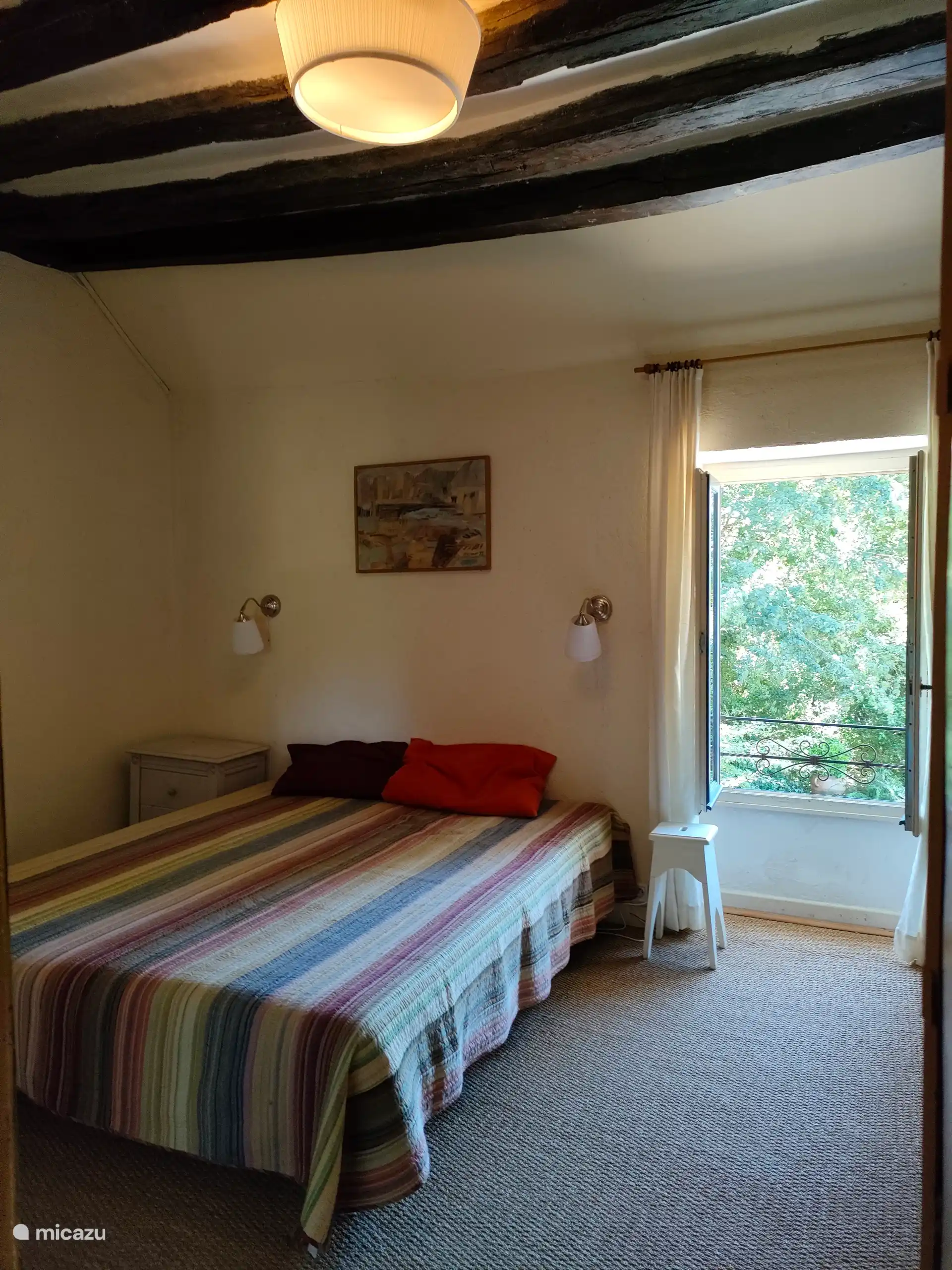 Schlafzimmer mit Doppelbett mit Blick auf den Vorgarten