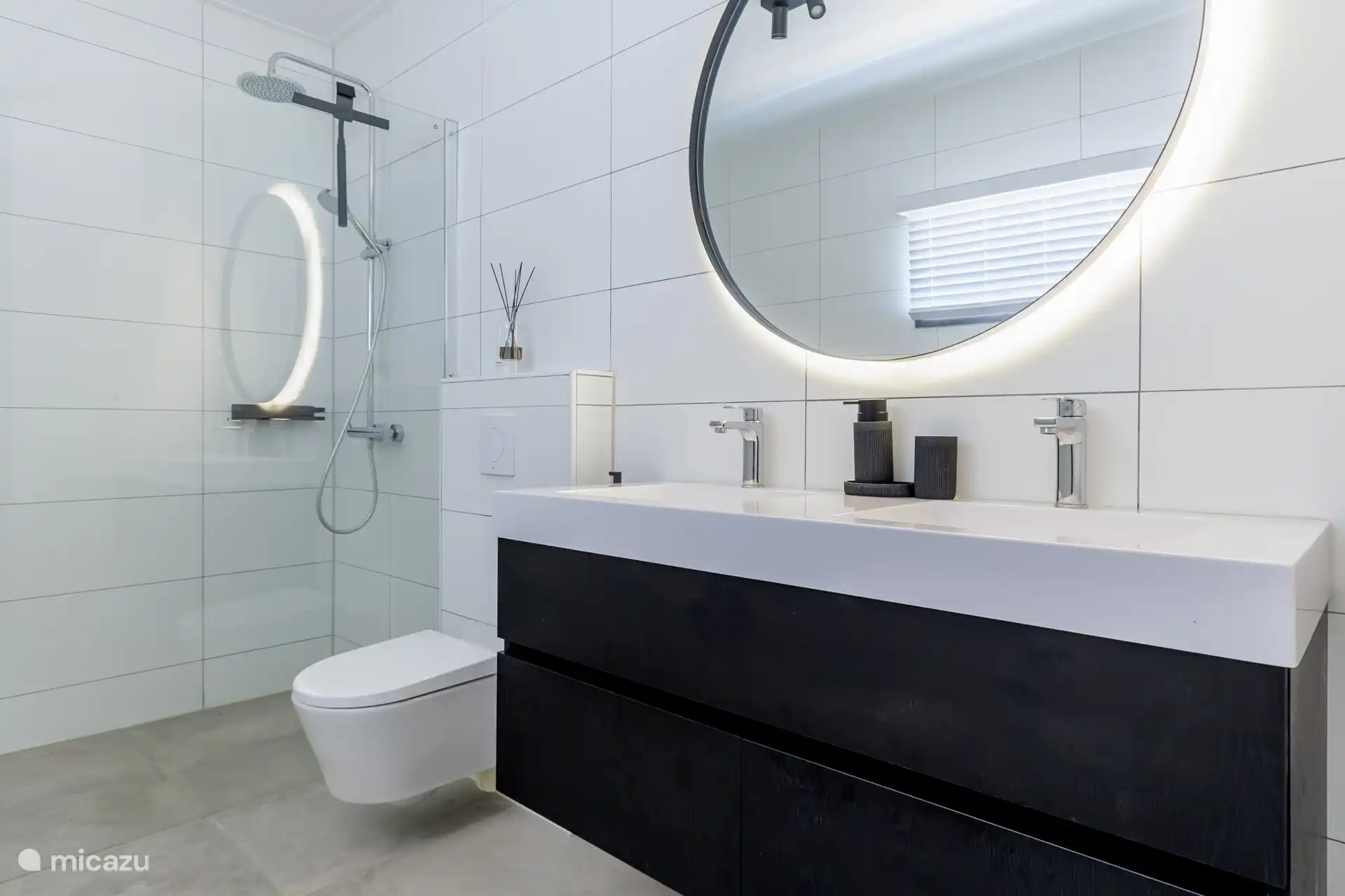 Spacious bathroom with walk-in shower, toilet and double sink