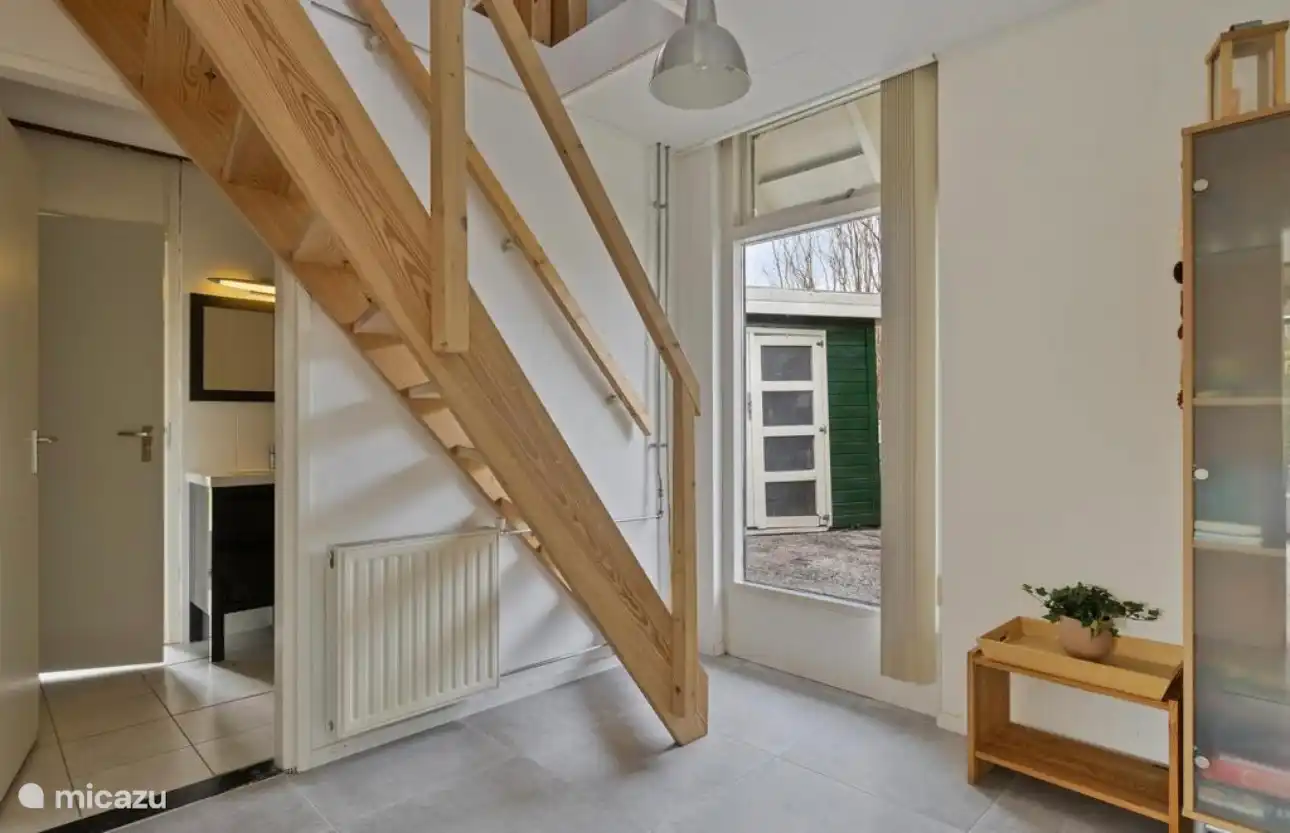 Helle Halle mit Holztreppe nach oben. Praktisch und stimmungsvoll!