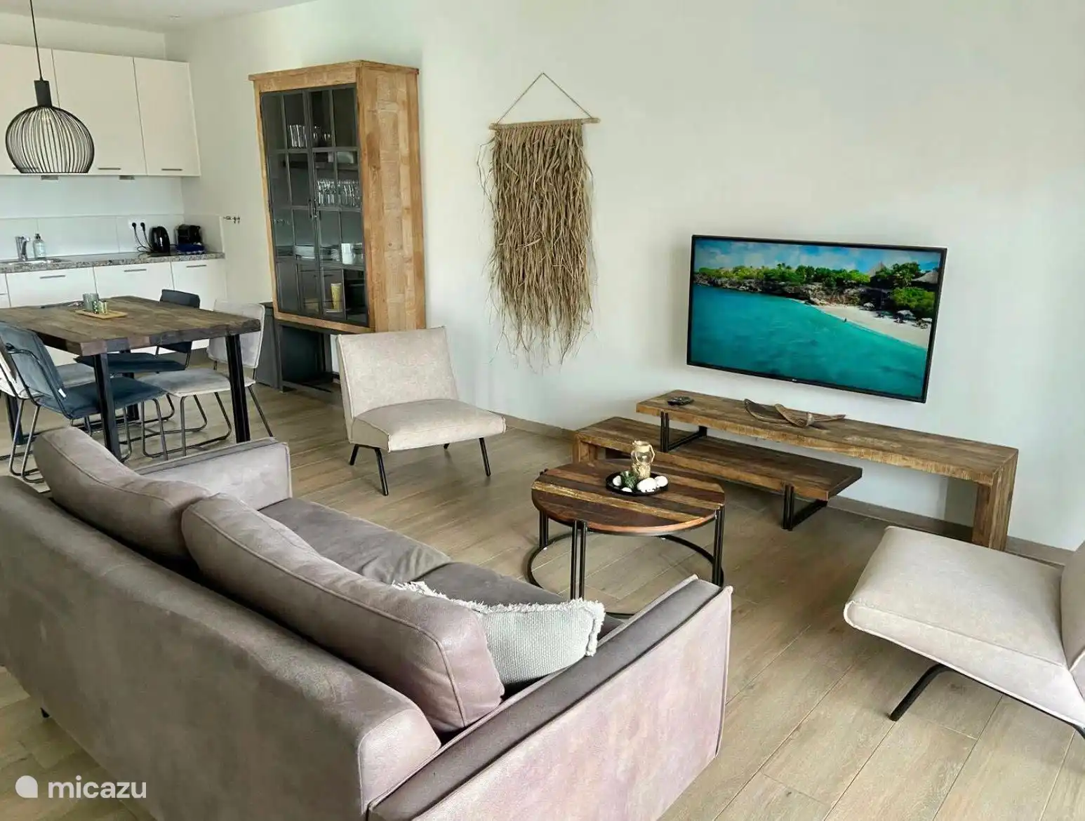 Un salon confortable avec coin repas, coin salon, climatisation, rideaux et une Smart TV. 