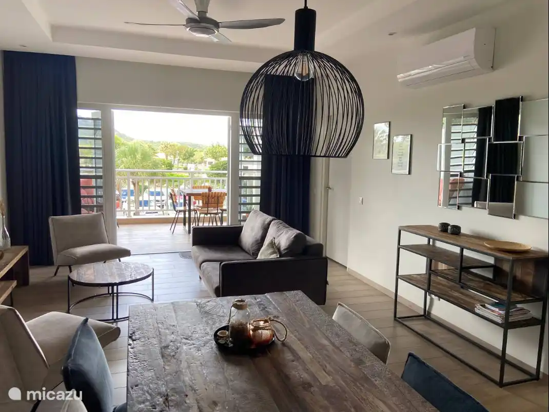 Salon spacieux avec climatisation et accès au balcon par des portes françaises. 