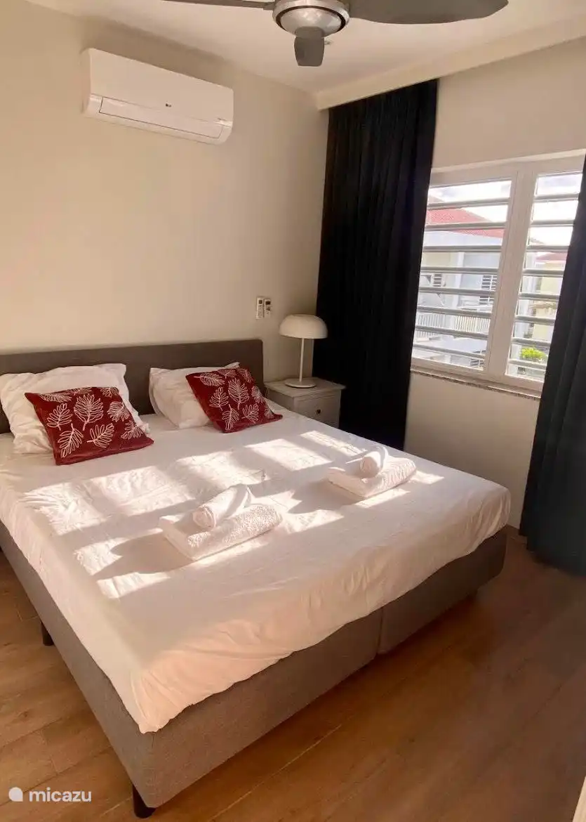 Chambre spacieuse avec climatisation, ventilateur et placard. 