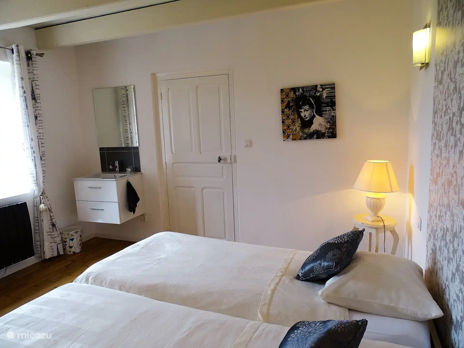 Schlafzimmer mit Doppelbett und Waschbecken.