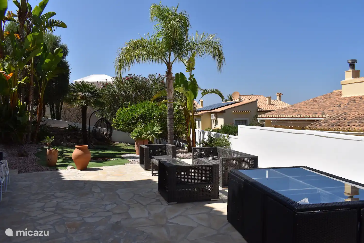 Vue sur la terrasse ensoleillée.
À l’arrière se trouvent des agrumes, dont les fruits peuvent également être utilisés par nos clients.