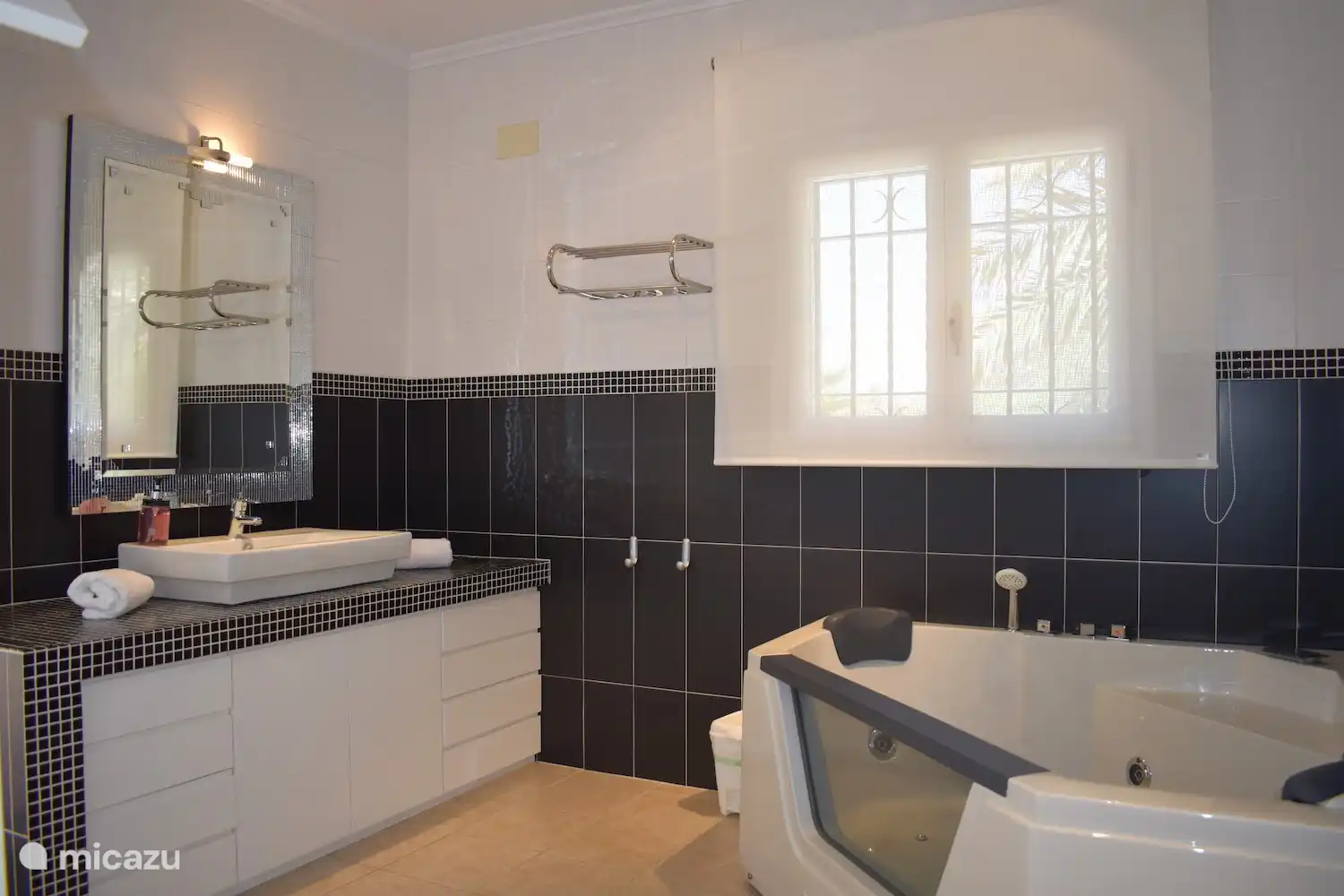 La salle de bain principale avec baignoire jacuzzi et douchette.
Cette salle de bain donne également accès à la terrasse orientée nord-ouest (avec vue sur la mer Méditerranée).