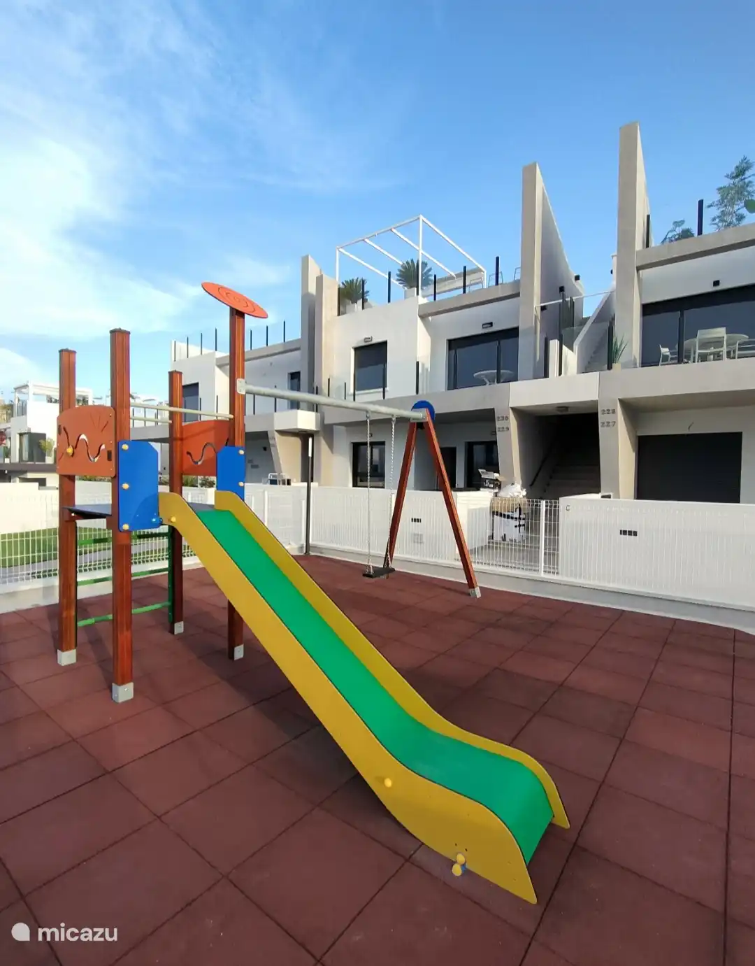 Aire de jeux clôturée à côté de la maison 