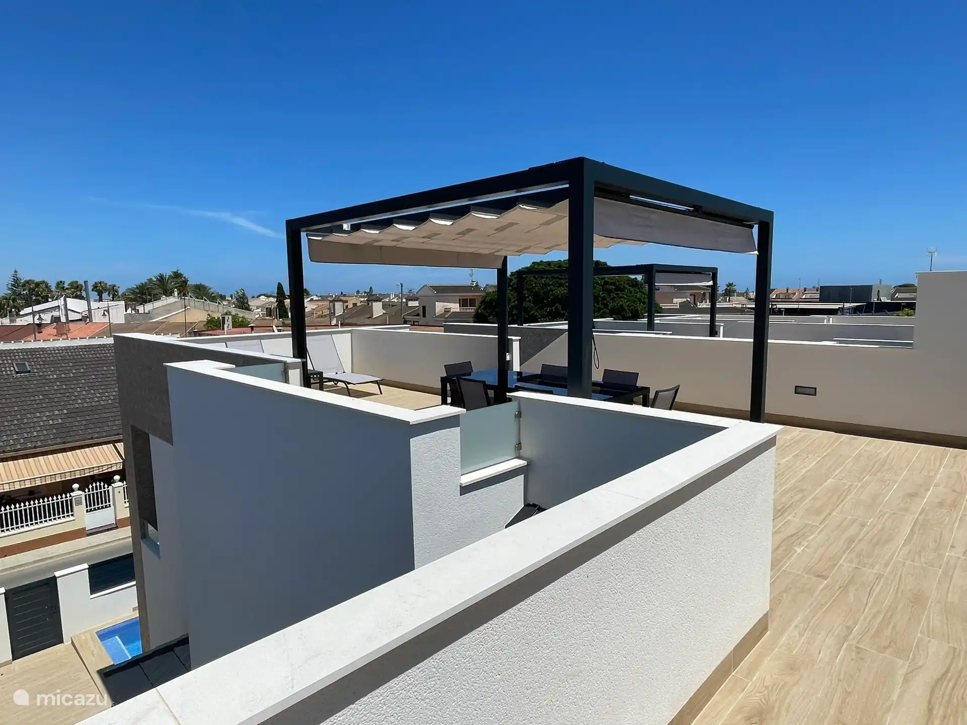Solarium con pérgola, mesa con 6 sillas y 2 tumbonas. Amplia vista de los alrededores.
