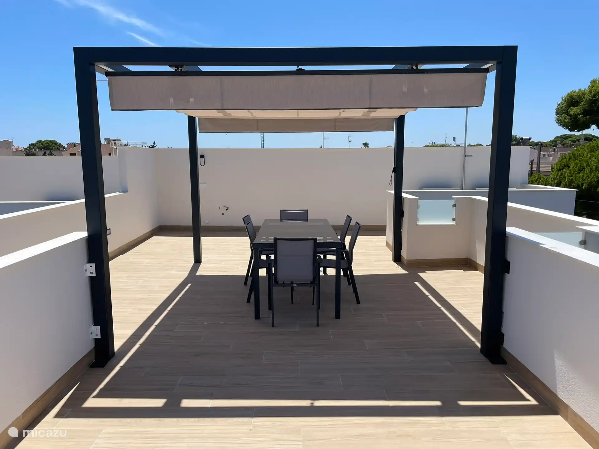 Solarium con pérgola, mesa con 6 sillas y 2 tumbonas. Amplia vista de los alrededores.