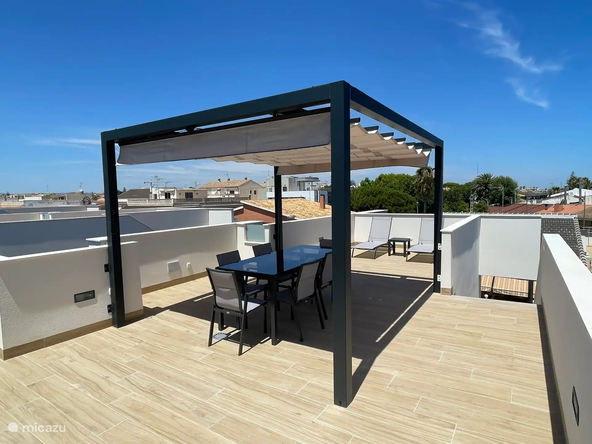 Solarium con pérgola, mesa con 6 sillas y 2 tumbonas. Amplia vista de los alrededores.