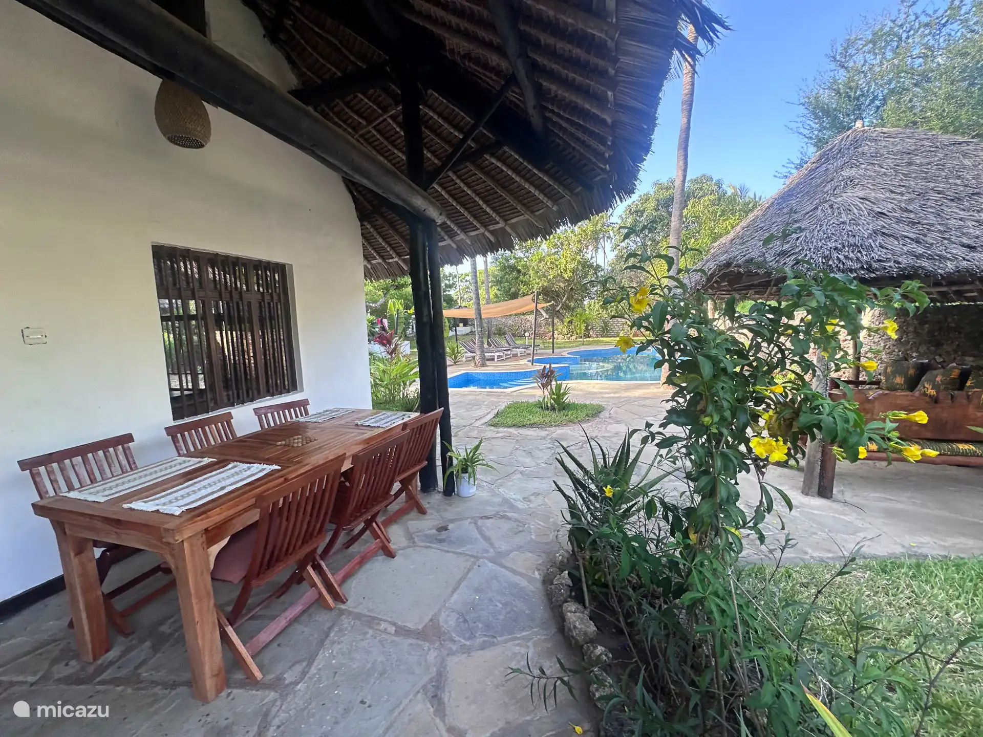 Esstisch draußen im Schatten vor dem Haus