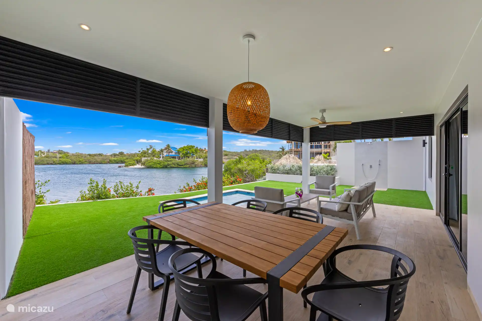 Privé veranda met eettafel en loungehoek—perfect voor buiten eten en genieten van de passaatwind