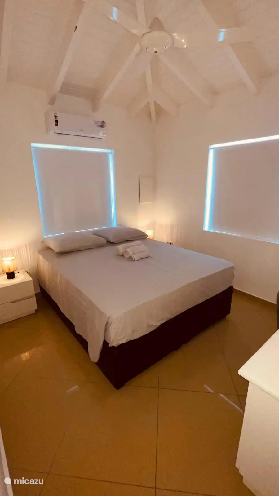 Slaapkamer 2 met kingsize bed, fan en airco en bureau.