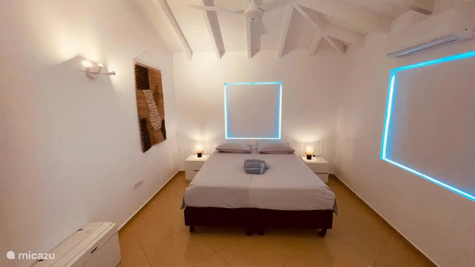 Slaapkamer 1 met Kingsize bed, fan en airco, walk-in-closet en eigen badkamer.