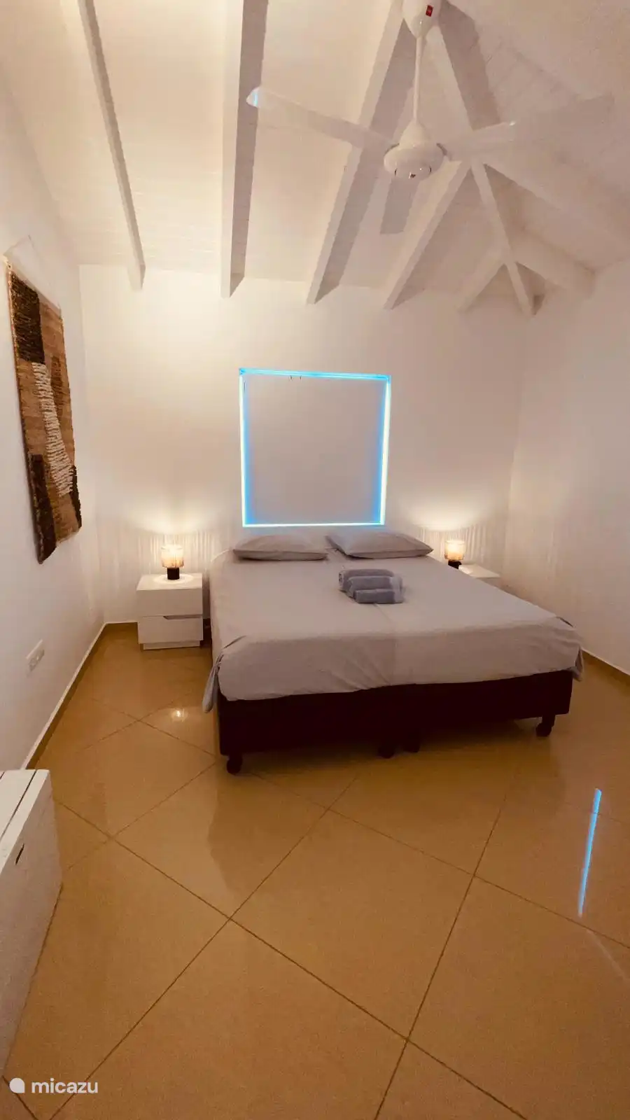 Slaapkamer 1 met Kingsize bed, fan en airco, walk-in-closet en eigen badkamer.