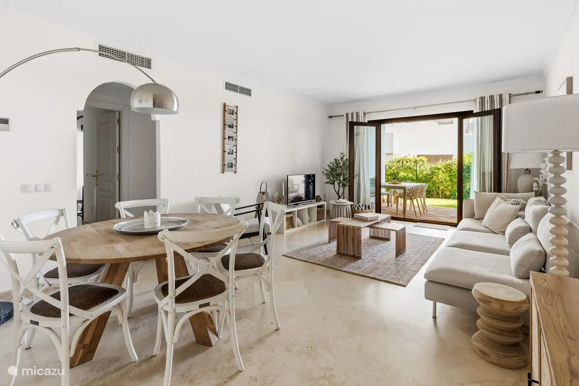 Aperçu du salon avec accès à la terrasse couverte et au jardin 